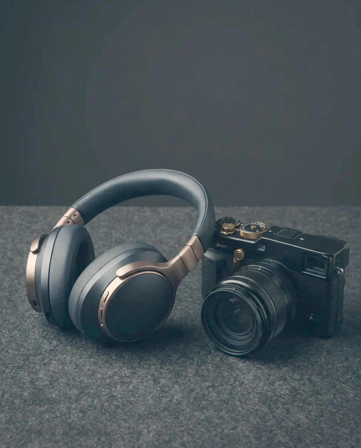Illustrative photograph of headphones beside a mirrorless camera