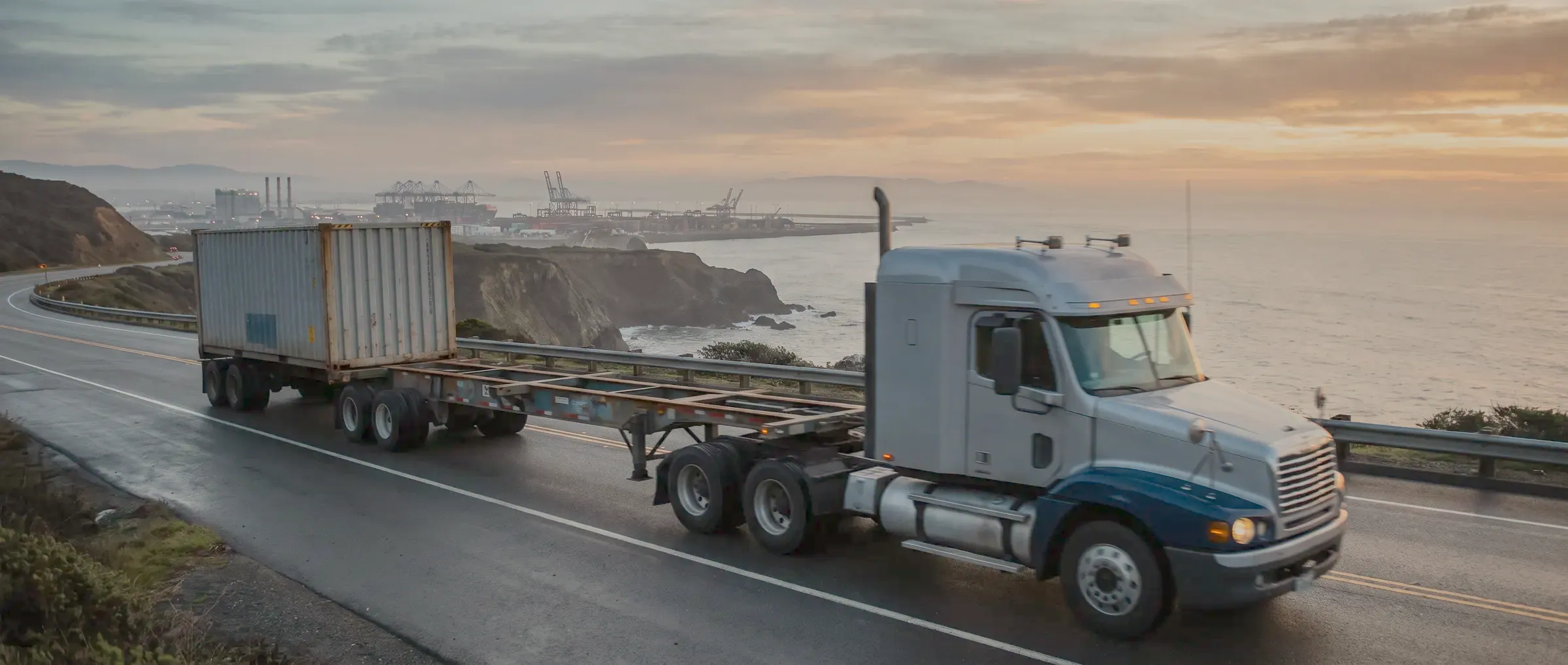 Container truck on a coastal road toward a port