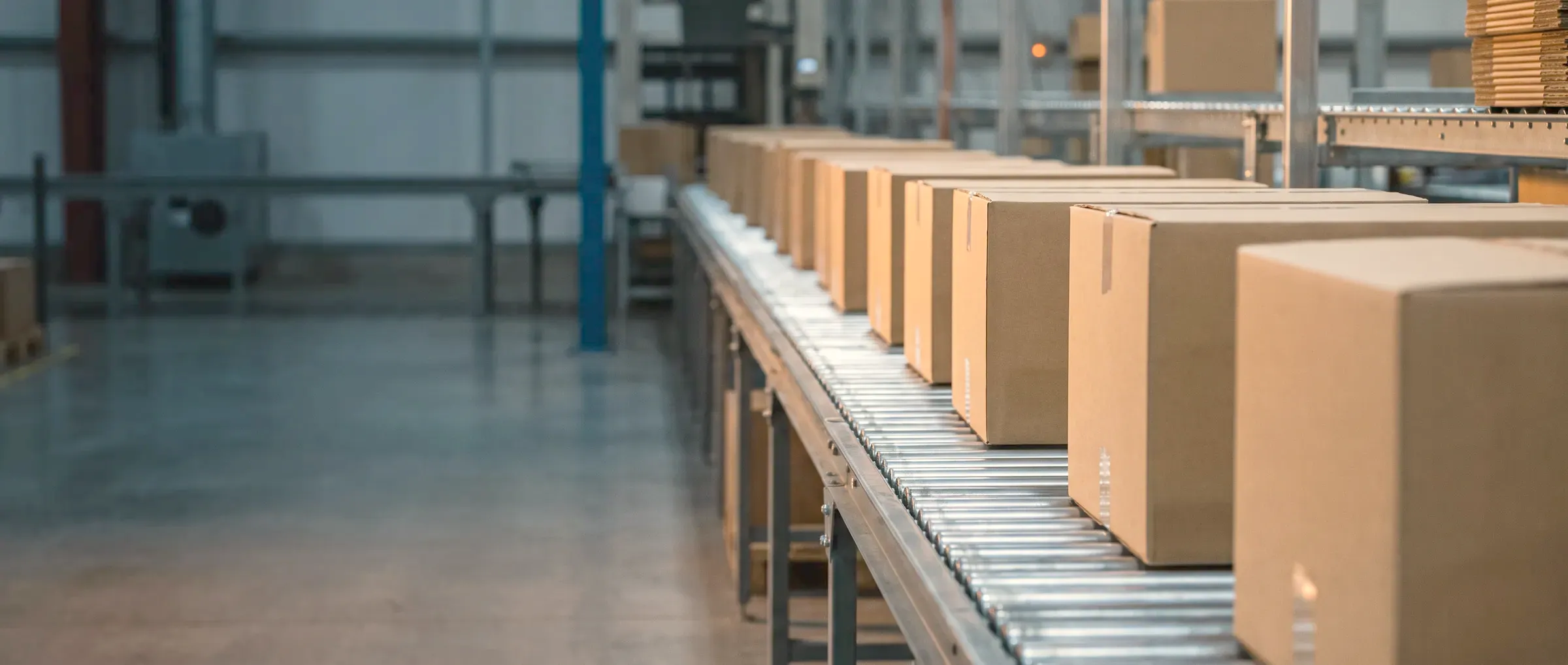 Cartons moving along a roller conveyor in a warehouse