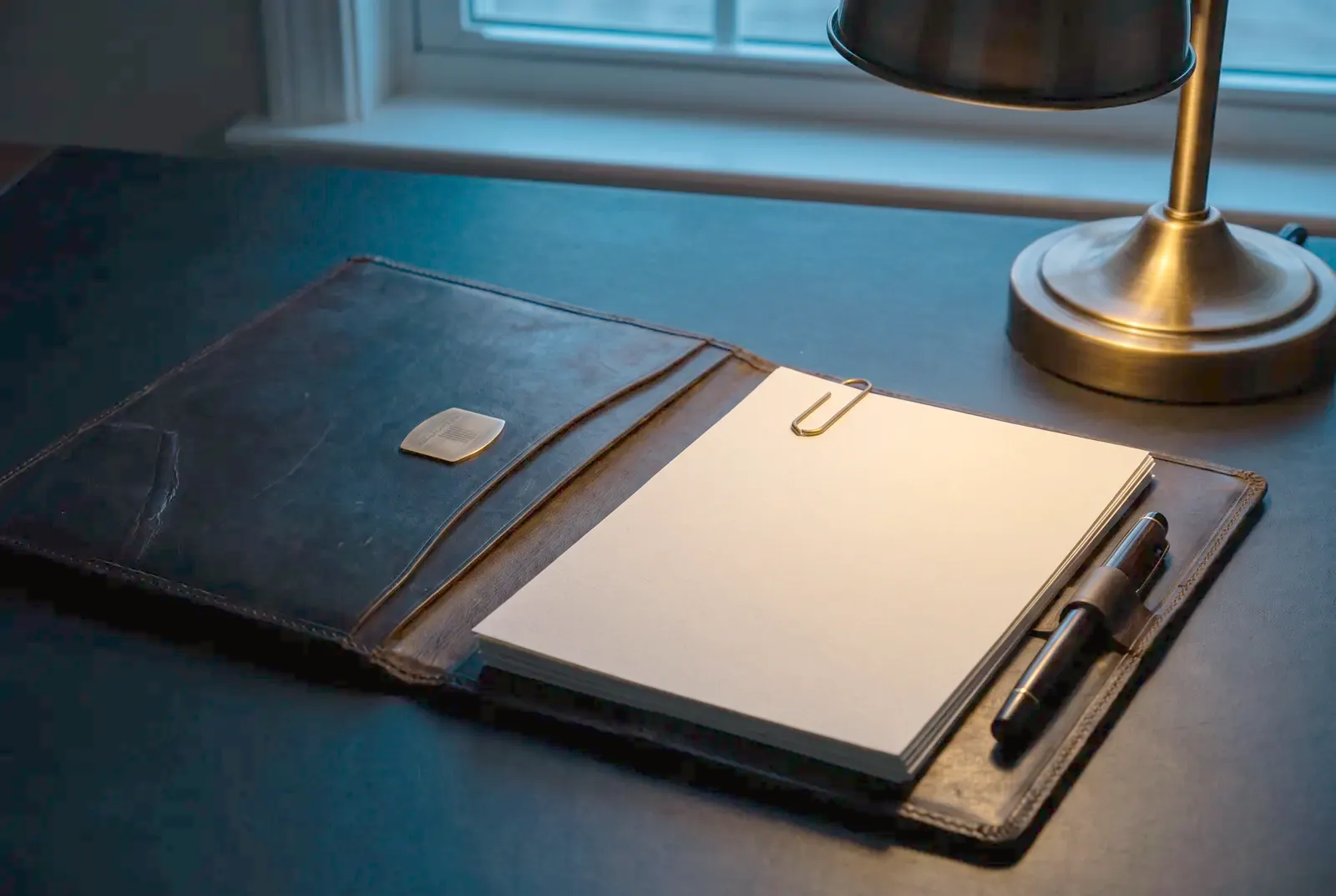 Shipping documents in a leather folder with a pen