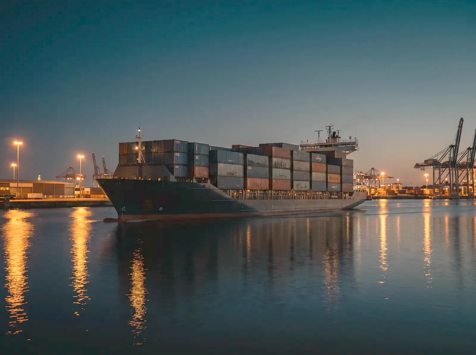 Container ship leaving a Gulf port at blue hour
